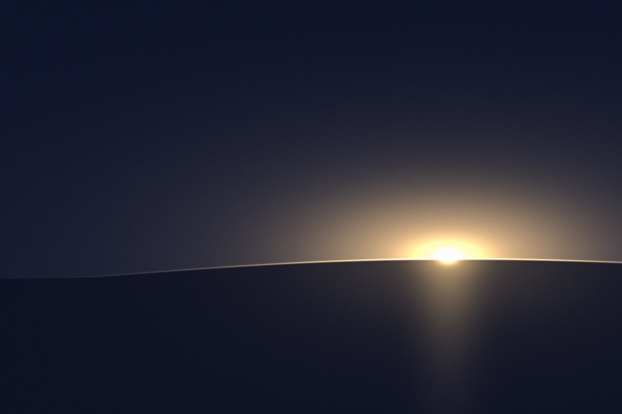 Sonnenaufgang über einem dunklen Horizont